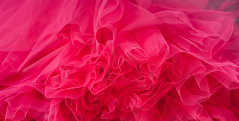 Red background of tulle fabric close-up.