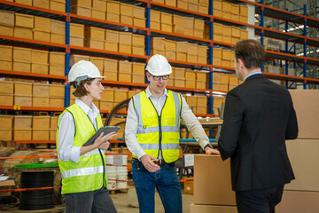 Warehouse managers and worker working together in warehouse office in a large distribution...