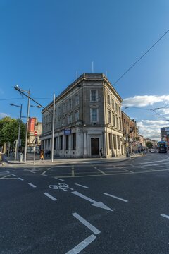 Angle shot of the old AIB bank branch from the corner with road signs on asphalt, Dublin, Ireland.