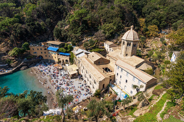 Aerial view of the ancient San Fruttuoso Abbey, X-XI century. Beach crowded with tourists near Portofino and Camogli, Genoa province (Genova), Liguria, Italy, Europe.