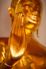 Buddha golden statue blessing hand, Wat Pho, Bangkok, Thailand. Low point of view