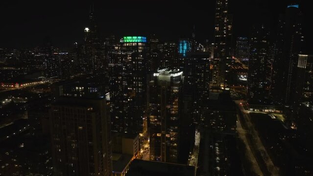 Drone shot around deluxe apartment buildings in South Loop, night in Chicago, USA