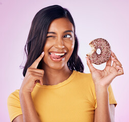 Donut, dessert and wink with woman in studio for diet, snack and happiness. Sugar, food and smile...
