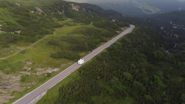 4K drone footage captures Swiss Alps' natural beauty as the sun sets through clouds at Gotthard Pass. Ideal for travel, tourism, and nature projects