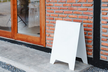 Empty white frame stand on cement floor with red brick vintage wall loft style. Blank advertising template. Creative art concept , space for text marketing promotion.