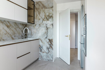 Modern kitchen with sink and faucet white door exit from kitchen