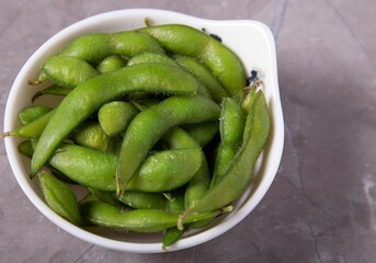 Closeup of organic edamame cooked with sea salt. Immature soybeans in the pod.