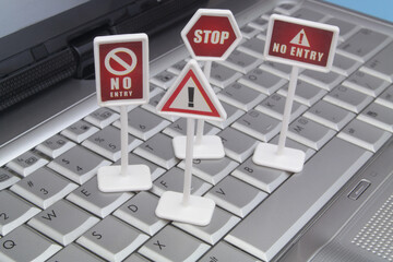 Censorship and banned access concept. Prohibition signs on silver computer keyboard close up.