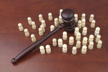 Rules and laws for people concept. Many wooden people and judge gavel.