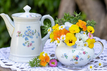 Blumenstrauß mit gelben und orange Hornveilchen in vintage Milchkanne	
