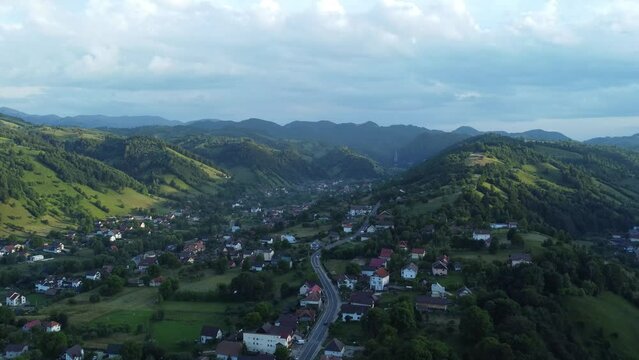 Aerial drone footage of the small village of Moeciu de Jos with houses and lush nature