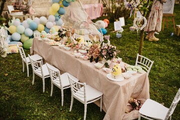 Table with food and cute decorations for a kid's birthday party in a garden in daylight