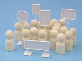 Meeting, demonstration and protest concept. Wooden people figures and white blank banners on blue background.	