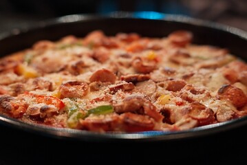 Closeup shot of a delicious deep dish pizza with meat and vegetable toppings