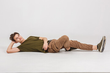 Fototapeta na wymiar fashion glamorous portrait of handsome boy is posing lying on white background in studio