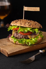 Delicious classic burgers with beef cutlets and cold beer on a dark background. Fast food. Street food.