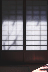 Frontal view of a traditional Japanese style shÅji as a blank background for Japanese themes. The paper walls in wooden frames let daylight into the interior.