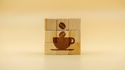 Coffee cup with coffee beans on wooden cubes against a yellow background