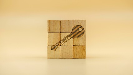 Key as a sign of security on wooden cubes against a yellow background