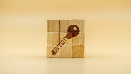 Key as a sign of security on wooden cubes against a yellow background