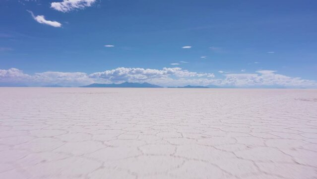 Uyuni Salt Flats on Sunny Day. Salar De Uyuni. Aerial View. Altiplano, Bolivia. Dry Season. Hexagonal Salt Formations. Drone Flies Forward at Low Level. Wide Shot