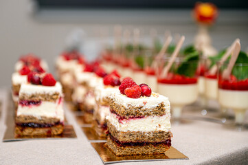 Close up of cakes with fresh fruits and berries arranged in a row on a party table