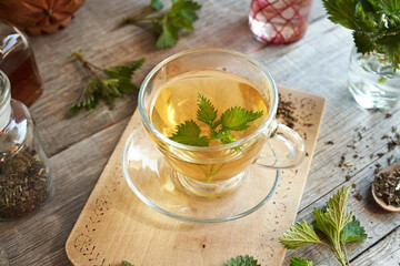 A cup of herbal tea with fresh stinging nettles