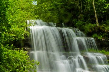 Fototapeta na wymiar Beautiful scenery of cascade waterfall with fresh vegetation