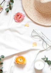 Summer concept composition with flowers on the white bed sheet. Top view frame. Copy space