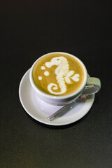 white cup with cappuccino with an intricate pattern.