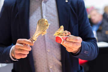a man in a suit puts ice cream in a paper cup.