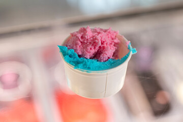 pink and blue ice cream in a paper cup
