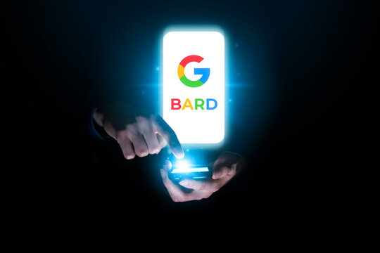 Google Bard AI search bot concept. Conversational artificial intelligence chatbot. Man chatting with bot on smartphone in dark blue technology environment.