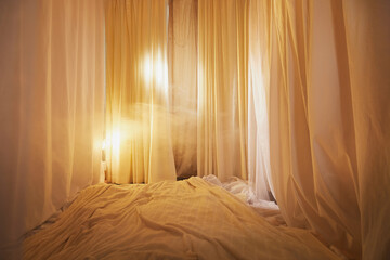 Light, soft transparent curtains in room. Canopy around bed with gentle light and blurring in...
