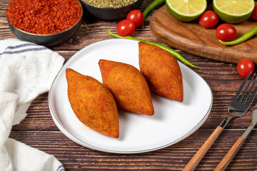Turkish stuffed meatballs. Arabian and Turkish cuisine flavored icli kofte or kibbeh on a wood background.