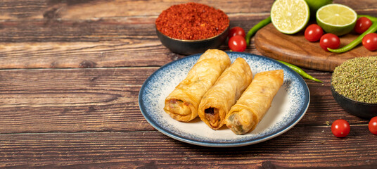 Pacanga pastry on wood background. Pastry made of phyllo with pastrami. Turkish cuisine delicacies. local name pacanga boregi. Copy space. Empty space for text