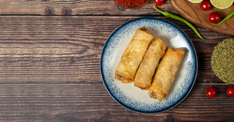 Pacanga pastry on wood background. Pastry made of phyllo with pastrami. Turkish cuisine delicacies. local name pacanga boregi. Top view. Copy space. Empty space for text