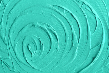 Aquamarine bentonite facial clay (alginate modeling mask, face cream, body wrap) texture close up, selective focus. Abstract turquoise background with swirl brush strokes.