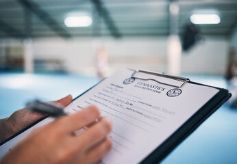Hand, documents and contract in gym with a coach watching a performance for membership sign up or checklist. Paper, assessment and personal trainer in a sports center for fitness, planning or review