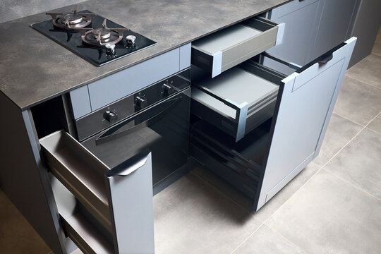 Vertical pull out rack cabinet drawer. Flush up slip handle finger pull handle of drawers for dishes, compact high pressure laminate HPL countertop, black glass gas stove cooker hob with two burners.