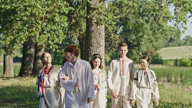 Happy Ukrainian people in national clothes walking in countryside
