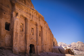Petra w Jordanii. Ruiny starożytnego miasta w skale na tle błękitnego, bezchmurnego nieba.