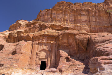 Petra w Jordanii. Ruiny starożytnego miasta w skale na tle błękitnego, bezchmurnego nieba. © rogozinski