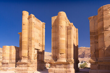Petra w Jordanii. Ruiny kolumn starożytnego miasta na tle błękitnego, bezchmurnego nieba. - obrazy, fototapety, plakaty