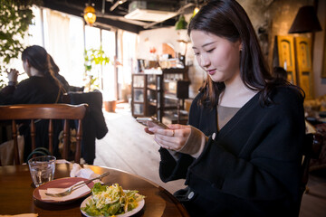 Woman taking pictures with smartphone at lunch　スマホで写真を撮る女性