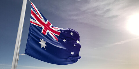 Australia national flag cloth fabric waving on beautiful sky Background.