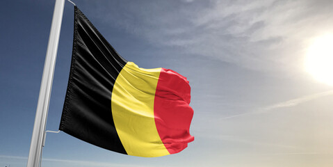 Belgium national flag cloth fabric waving on beautiful sky Background.
