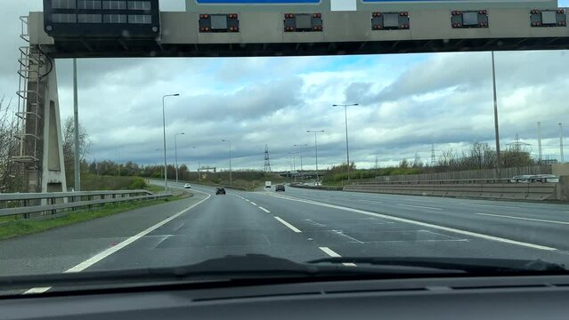 Driving car windscreen and dashboard view leaving A1 highway at Junction 41, J41 and turning to M62 near Pontefract, Leeds, England.