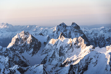 View of Mount Ushba and snow-covered peaks on sunrise from the top of Mount Elbrus