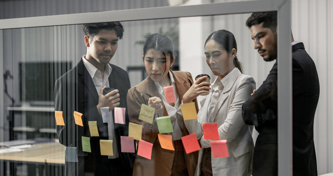 Businessperson discuss, exchange ideas and develop fresh perspectives by using sticky notes. Working collaboratively as a team help generate innovative ideas and potential solutions for the company.